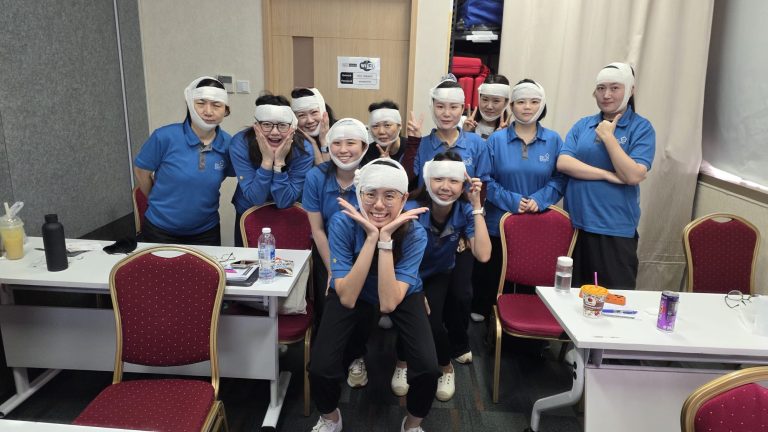 Learners attending Child First Aid course, learning bandaging techniques