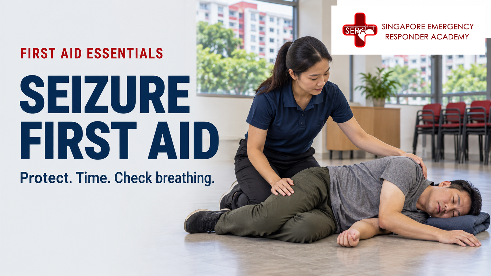 First aider supporting an adult resting on their side after a seizure in a Singapore community room.