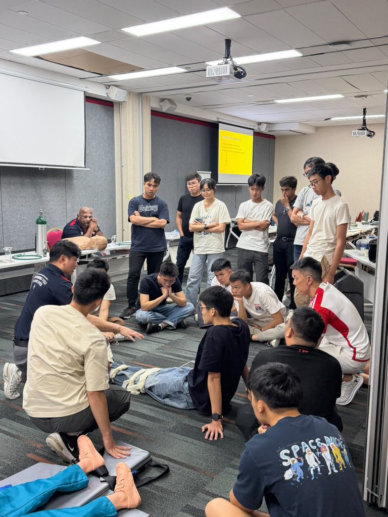 Participants in first aid class learning bandaging techniques together